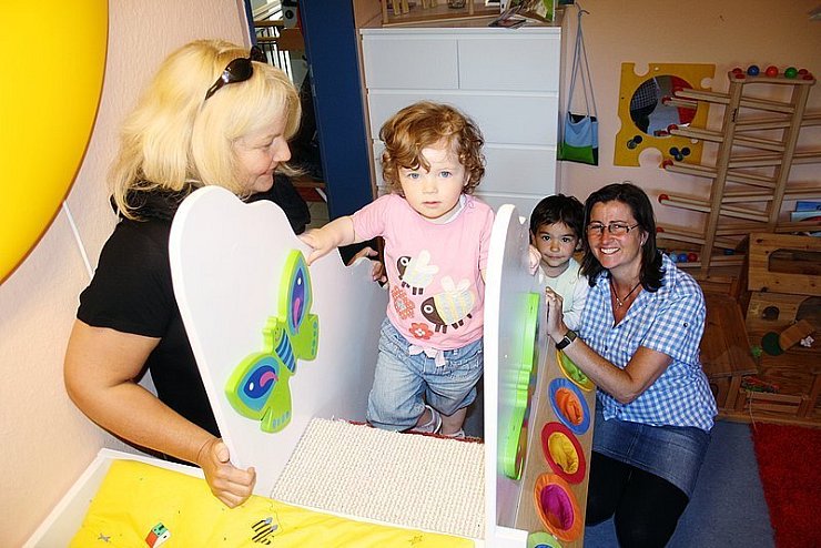 So klappt es: Ein paar selbst genommene Treppen zum Wickeltisch geben Lea (2) Sicherheit. Aike Overdiek-Spilker (links) und Petra Kammler freut es genauso wie Gülcan (3). - © Foto: Stracke