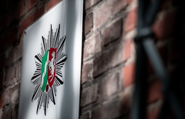 Das Wappen der Polizei Nordrhein-Westfalen hängt an der Wand eines Polizeipräsidiums (Symbolbild). - © Fabian Strauch/dpa