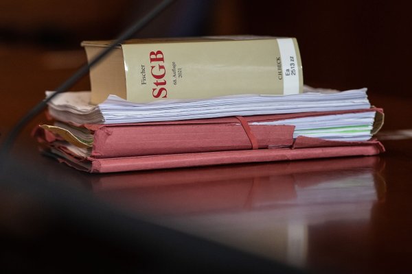 Das Strafgesetzbuch und Akten liegen in einem Gericht auf dem Tisch. - © Swen Pförtner/dpa/Symbolbild