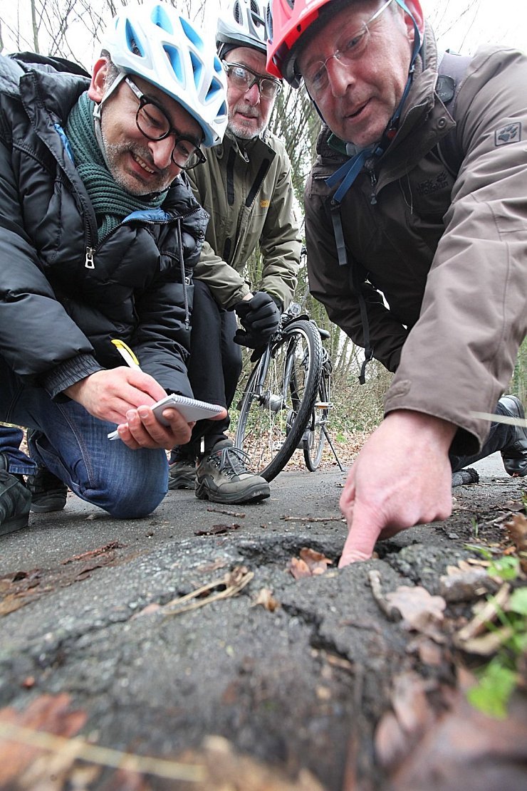 Frank Loke, Werner Kloppmann und LZ-Redakteur Erol Kamisli (von links) nehmen den aufgerissenen Asphalt auf dem Radweg an der Rintelner Straße unter die Lupe. - © Vera Gerstendorf-Welle