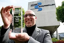 Glasklare Auszeichnung: Christian Jaschinski zeigt den "Studienpreis 2009", der dem Hanse-Berufskolleg verliehen worden ist. Foto Backe