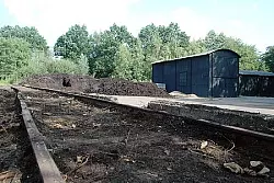 Zwischenlager: Dorthin wird der Rohstoff von der Diesellok auf einem 300 bis 400 Meter langen Schienenstrang, der ständig von Hand neu verlegt werden muss, transportiert. - © Foto: Brinkmeier