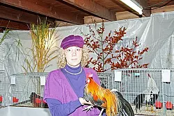 Farbenfroh: Ausstellungsleiterin Christa R&uuml;senberg mit Hahn.Foto: Blum