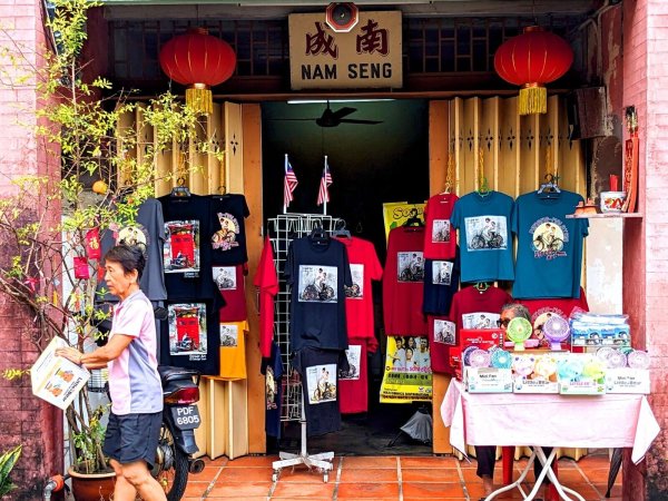 T-Shirts und andere Dinge, auf denen Street Art-Kunstwerke aus Penang abgebildet sind, werden in einem Geschäft zum Kauf angeboten. - © Genevieve Tan Shu Thung/dpa