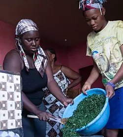 Die 17-j&auml;hrige Fatima (r.) und Mitarbeiterin Mariatu kochen gemeinsam im Waisenhaus. - &copy; Florian Juchhoff