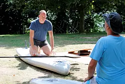 Bevor es beim Stand-Up-Paddling ins Wasser geht, wird an Land das Aufstehen auf dem Brett geprobt. - &copy; Daniel Peters