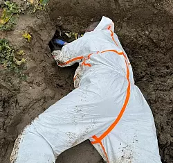 Voller K&ouml;rpereinsatz: der schlammige Boden drohte immer wieder in die Rohr&ouml;ffnung zu geraten. - &copy; Feuerwehr Horn-Bad Meinberg