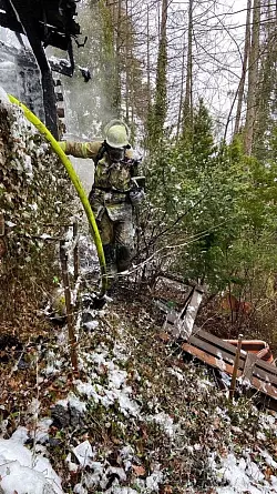 Die Feuerwehr ist unter Atemschutz auf dem unwegsamen Gel&auml;nde im Einsatz. - &copy; Feuerwehr L&uuml;gde