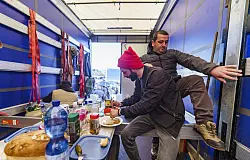 LKW-Fahrer bereiten Essen in einem LKW-Auflieger zu, der während des Streiks zum Küchen-Truck umfunktioniert wurde. Auf der Raststätte Gräfenhausen bei Darmstadt streiken Lastwagenfahrer, die unter anderem aus Georgien und Usbekistan kommen. - © dpa