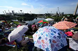 Mit Schirmen versuchten viele Fans, sich vor der Sonne zu sch&uuml;tzen. - &copy; Felix H&ouml;rhager/dpa