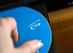 Am Besten die DVD am Rand oder dem Loch in der Mitte halten - so bleibt die Oberfläche frei von Fingerabdrücken. - © Christin Klose/dpa-tmn