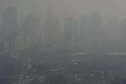 Die Hochhäuser der Metropole sind wegen der Luftverschmutzung kaum sichtbar. - © Sakchai Lalit/AP/dpa