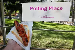Ein Grillwürstchen mit Zwiebeln und Ketchup gehört in Australien fest zum Wahltag - alles für den guten Zweck. - © Pat Hoelscher/AP/dpa