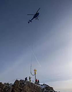 Ein Helikopter holt das Kreuz zur Restaurierung ab. (Archivbild) - © Peter Kneffel/dpa