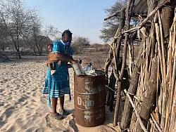 Landwirtin Rebecca Gatshele bereitet ein Gemisch aus Chili und Elefantendung zu, dass sie auf ihrem Feld verbrennt, um Elefanten davon abzuhalten, ihre Ernte zu fressen. - © Kristin Palitza/dpa