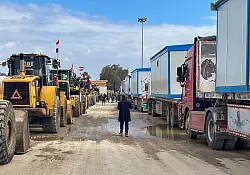 Bulldozer und Lastwagen mit Wohncontainern warten am Rafah-Grenzübergang. (Archivbild) - © Mohamed Arafat/AP/dpa