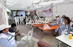 Helfer ruhen sich im Schatten von den Strapazen und der Hitze aus und haben einen Ventilator im Erste-Hilfe-Zelt angestellt. - &copy; Carola Frentzen/dpa