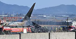Das Flugzeug zerschellte an einer Mauer und ging in Flammen auf. - © Lee Young-ju/Newsis/AP/dpa