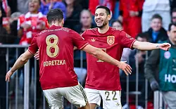 Raphael Guerreiro (r) jubelt mit Leon Goretzka, seine zwei Treffer reichten aber nicht zum Bayern-Sieg. - © Sven Hoppe/dpa