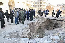 Frühere Bewohner des Viertels Dschubar zeigen Entwicklungsministerin Svenja Schulze (SPD), die Tunnel der Rebellen aus der Zeit des Bürgerkrieges. - © Sebastian Gollnow/dpa