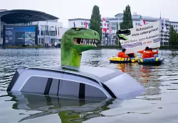 Schon vor der offiziellen Er&ouml;ffnung protestierte Attac mit einem &laquo;Autosaurus&raquo; am M&uuml;nchner Messegel&auml;nde. - &copy; Sven Hoppe/dpa