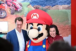 Beim Messerundgang über die Gamescom kam der Tross von Politikern auch beim Messestand von Nintendo vorbei, hier stehen NRW-Ministerpräsident Hendrik Wüst (CDU) und Bundesforschungsministerin Dorothee Bär (CSU) neben einer Mario-Plüschfigur. - © Wolf von Dewitz/dpa