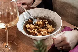 Sieht lecker aus: mit Bergkartoffel, Graukäse und Wildkräutern gefüllte Tortellini in Speck-Zwiebel-Brühe, serviert auf der Ütia «I Tablá». - © Manuel Glira/Alta Badia/dpa-tmn