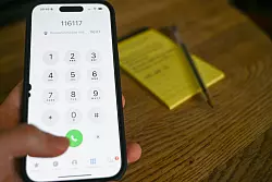 Eine Frau wählt auf einem Handy die Nummer das Kassenärztlichen Notdienstes (116 117). (Archivbild) - © Katharina Kausche/dpa