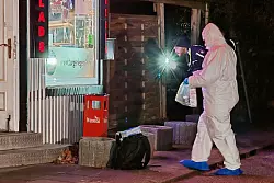 Ermittler der Polizei suchen am Tatort nach Spuren. - © Carsten Neef/News & Art/dpa