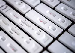 Antigen-Schnelltests für den Nachweis von SARS-CoV-2 liegen auf einem Tisch. In Nordrhein-Westfalen gab es in den drei Jahren der Corona-Pandemie mehr als acht Millionen nachgewiesene Erkrankungen. - © Sina Schuldt/dpa