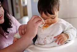 Das kann keiner vermeiden: Breireste auf Lätzchen und meist auch noch auf der Kleidung von Babys und Kleinkindern. - © Mascha Brichta/dpa-tmn