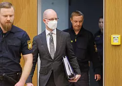 Der frühere Wirecard-Manager und Kronzeuge Oliver Bellenhaus (M) kommt zur Fortsetzung des Prozesses in den Münchner Gerichtssaal. - © Lukas Barth/dpa