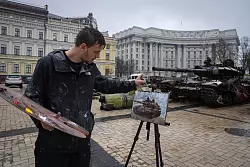 Der britische K&uuml;nstler Max Denison-Pender malt in Kiew eine Ausstellung besch&auml;digter russischer Panzer. - &copy; Efrem Lukatsky/AP