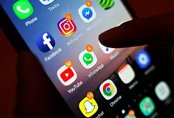 Ein Smartphone-Display mit Symbolen von Apps, die man auch zum Telefonieren und Videotelefonieren nutzen kann, etwa Facebook Messenger und Whatsapp. - © Yui Mok/PA Wire/dpa