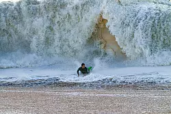 Ein Surfer taucht in Seal Beach aus den Wellen auf. - &copy; Damian Dovarganes/AP
