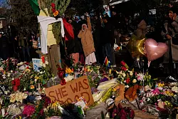 Menschen versammeln sich um eine provisorische Gedenkst&auml;tte zu Ehren der Frau, die von einem ICE-Beamten t&ouml;dlich erschossen wurde. - &copy; John Locher/AP/dpa