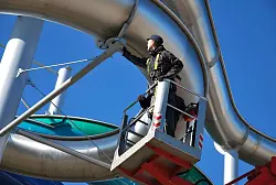 Ferdinand Ziegler vom T&Uuml;V S&uuml;d pr&uuml;ft eine Wasserrutsche auf dem Au&szlig;engel&auml;nde der Therme Erding. - &copy; T&Uuml;V S&uuml;d/dpa