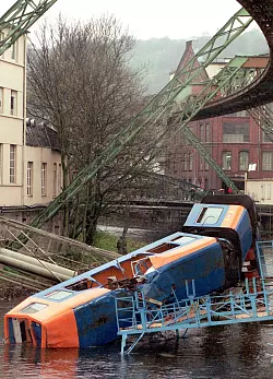 Der abgest&uuml;rzte Zug der Wuppertaler Schwebebahn im Wuppertaler Stadtteil liegt am 12. April 1999 im Fluss. - &copy; Oliver Multhaup/dpa