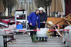 Helfer bringen noch lebende Fische in Wasserbecken aus dem Geb&auml;ude. - &copy; Soeren Stache/dpa