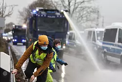 Viele AfDler kamen wegen Straßenblockaden erst spät zur Messe in Gießen. Die Polizei setzte Wasserwerfer ein, um Wege freizuräumen. - © Hannes P. Albert/dpa