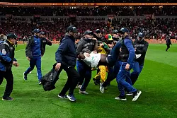 Ein auf das Spielfeld gest&uuml;rmter Anh&auml;nger des Senegal wird von Sicherheitskr&auml;ften vom Platz getragen. (Archivbild) - &copy; Themba Hadebe/AP/dpa