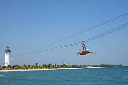 Abflug aus dem Leuchtturm: Auf der Norwegian-Insel Harvest Caye vor Belize gibt es eine Zipline &uuml;ber die Lagune. - &copy; Stephen Beaudet/Norwegian Cruise Line/dpa-tmn