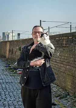 Geht morgens mit ihr am Bahnhof in Darlington spazieren: Gareth Shepherd und seine Katze Dottie. - © Stephan Weißenborn/dpa-tmn