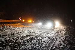 Autofahrer sind auf einer verschneiten Straße bei Niedernhausen (Hessen) unterwegs. - © Jörg Halisch/dpa