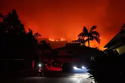 Über Nacht breitete sich das Feuer in Malibu rasch aus. - © Jae C. Hong/AP/dpa