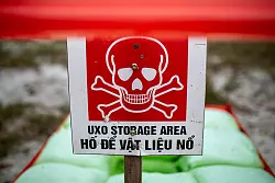 Ein Lager f&uuml;r Blindg&auml;nger im Dorf Ha Tay ist mit einem Warnschild mit Totenkopfsymbol markiert. - &copy; Chris Humphrey/dpa