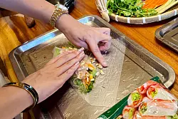 Kursleiterin Alice erklärt, wie frische Sommerrollen richtig zubereitet werden. - © Carola Frentzen/dpa-tmn