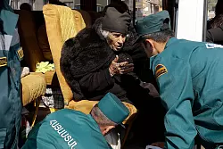 Mitarbeiter des armenischen Ministeriums f&uuml;r Notfallsituationen sprechen mit einer &auml;lteren armenischen Frau aus Berg-Karabach bei ihrer Ankunf in Goris. - &copy; Vasily Krestyaninov/AP/dpa