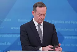 Bundesverkehrsminister Volker Wissing (FDP) blickt bei einer Pressekonferenz im M&auml;rz 2022 auf sein Smartphone. - &copy; Joerg Carstensen/dpa