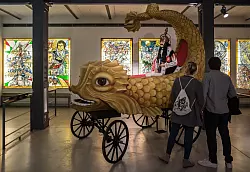 Besucher des K&ouml;lner Karnevalsmuseums besichtigen einen originalgetreuen Nachbau des sogenannten &laquo;Heldenwagens&raquo; aus dem ersten K&ouml;lner Rosenmontagszug von 1823. - &copy; Costa Belibasakis/Festkomitee K&ouml;lner Karneval